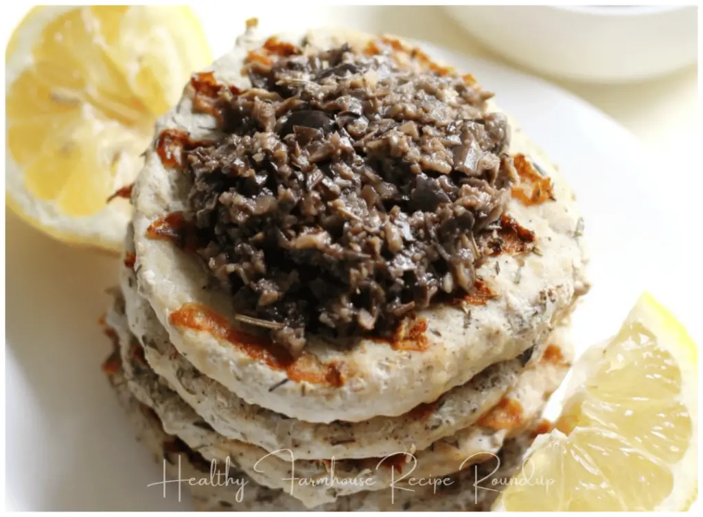 Stack of healthy chicken burger patties topped with black olives