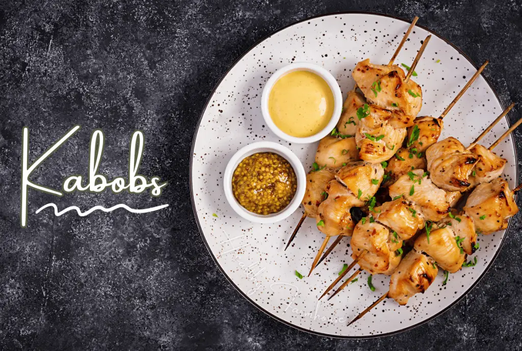 Chicken kabobs on a plate with dipping sauces.