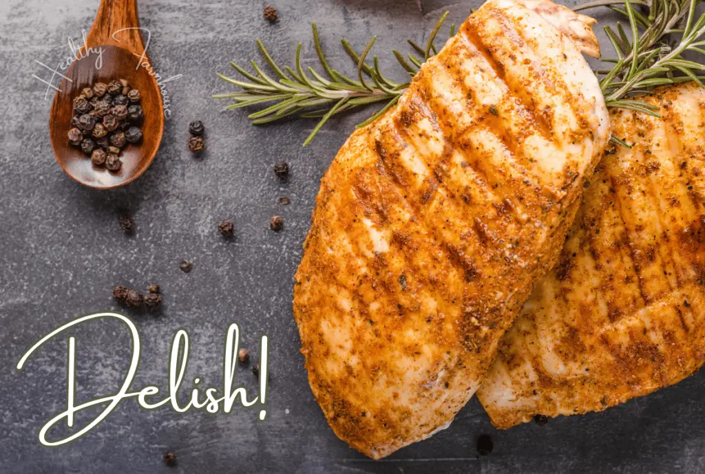 Grilled chicken breasts with rosemary sprigs, a spoonful of peppercorns, and the word delish!