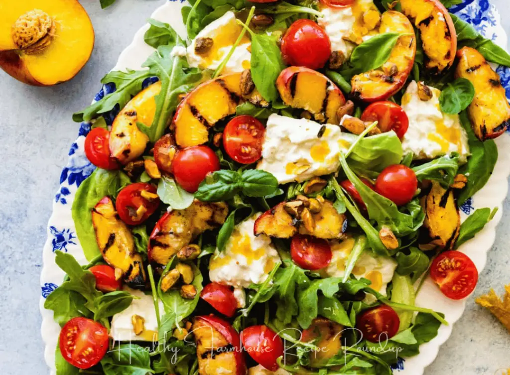 Healthy grilled peach salad with vegetables, tomatoes, and greens