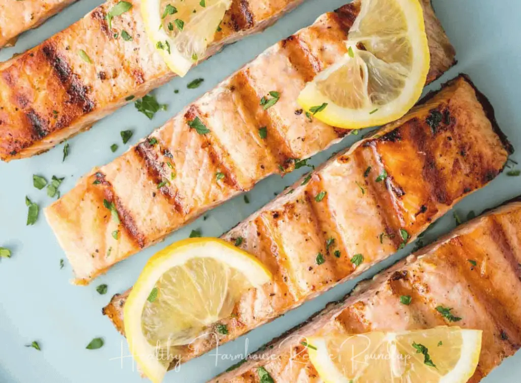 Thinly sliced salmon fillets with lemon wedges