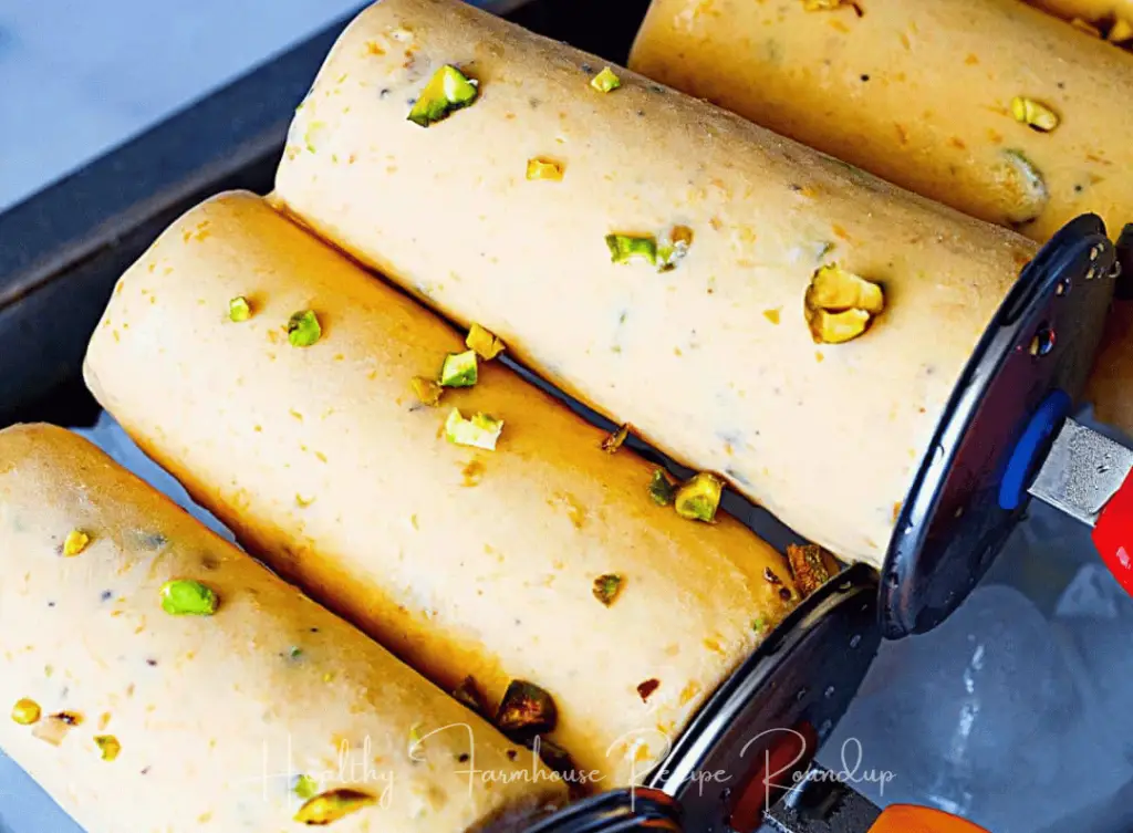 Creamy round mango popsicle sprinkled with pistachios