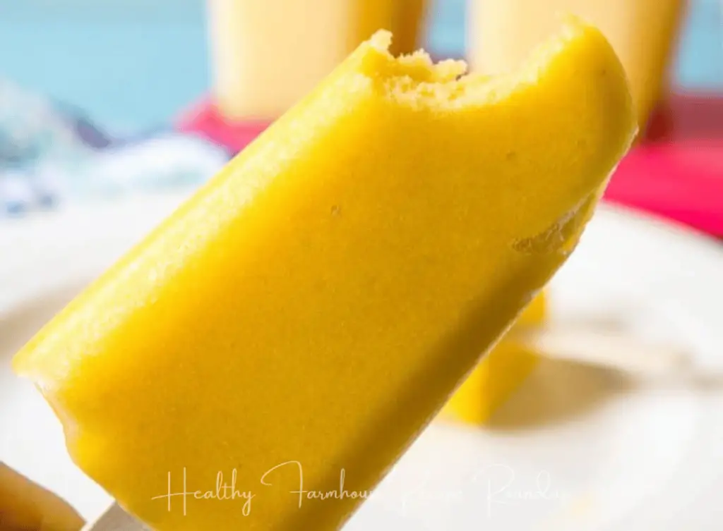 mango popsicle with bite taken out of it