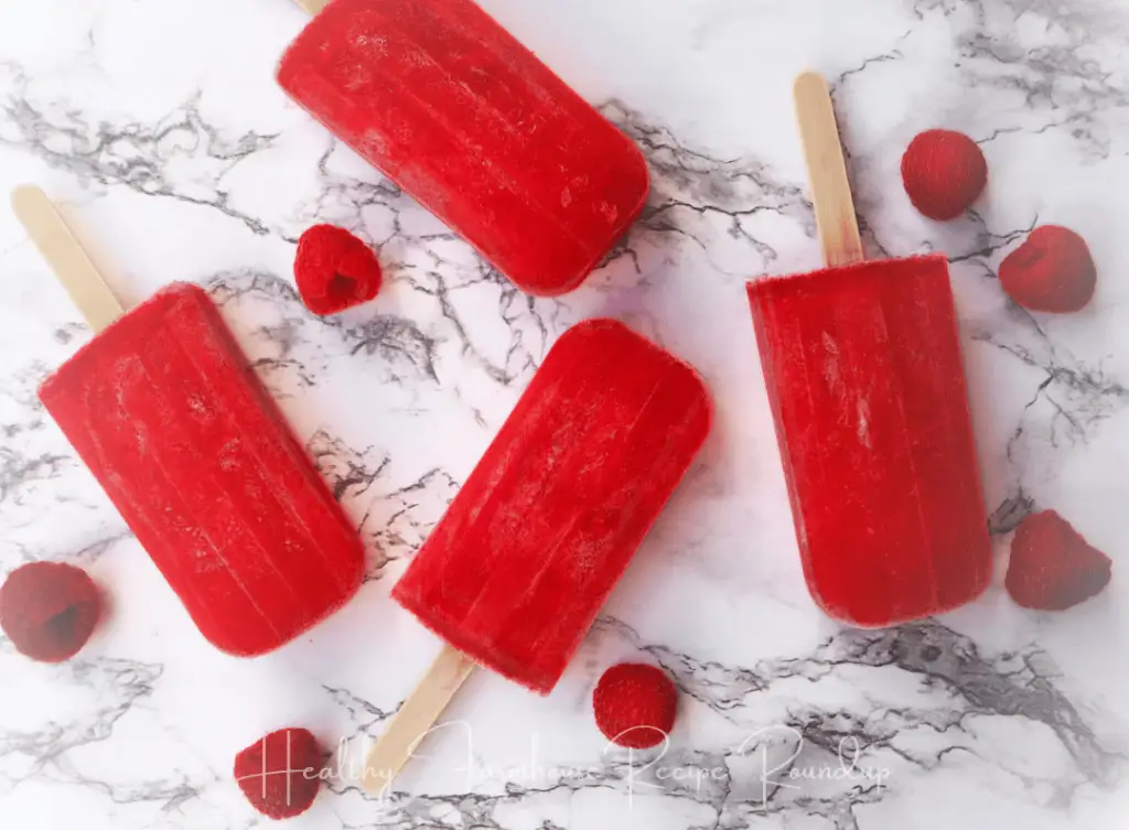 4 red popsicles with raspberries