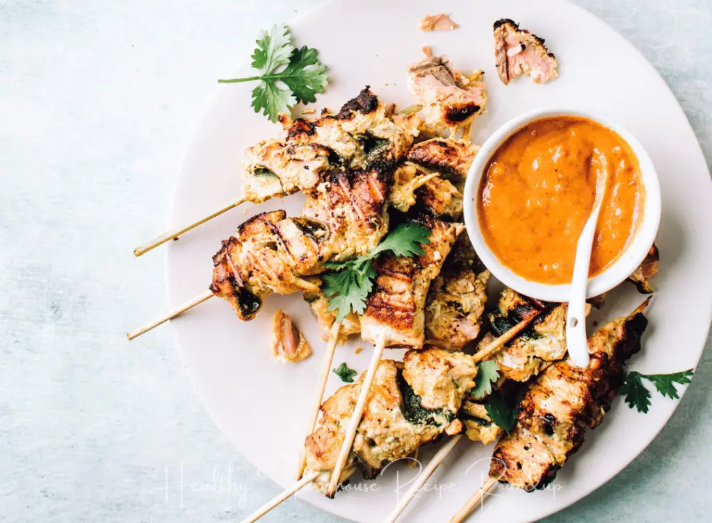 Salmon skewers with bowl of dipping sauce