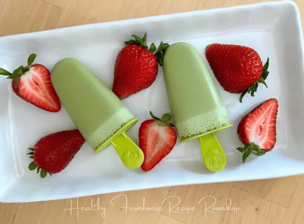 Healthy green matcha popsicle recipe on a plate with sliced strawberries
