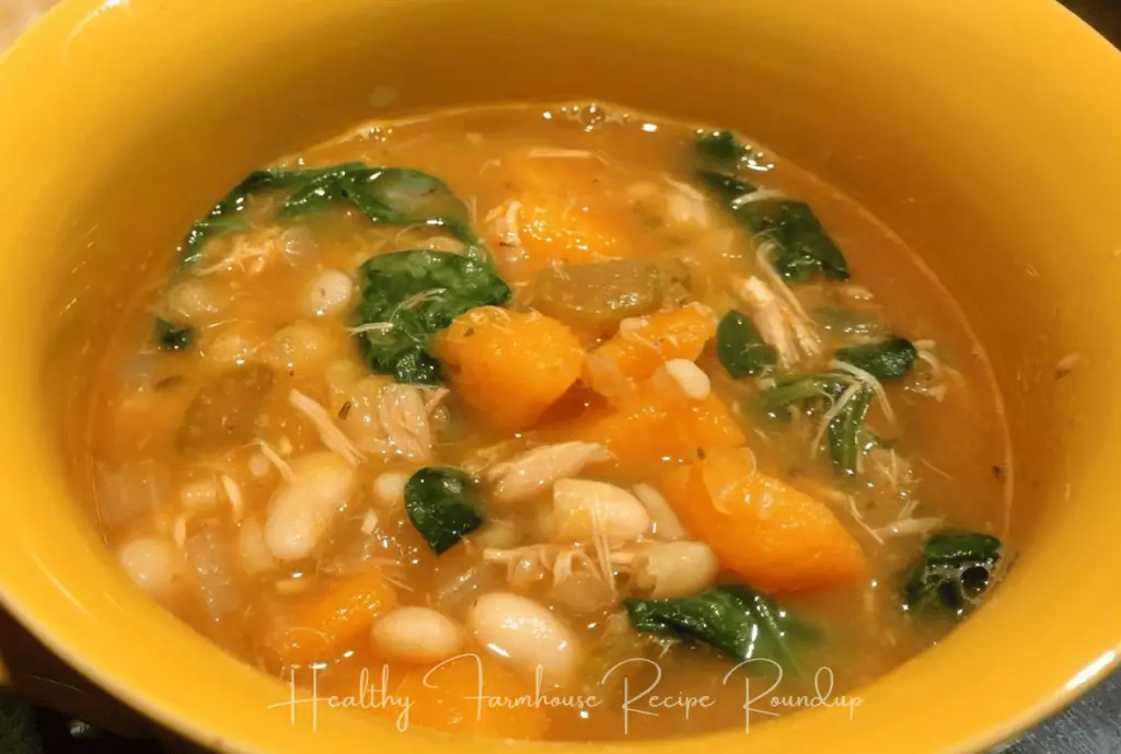 Yellow bowl filled with bean and butternut squash soup with greens