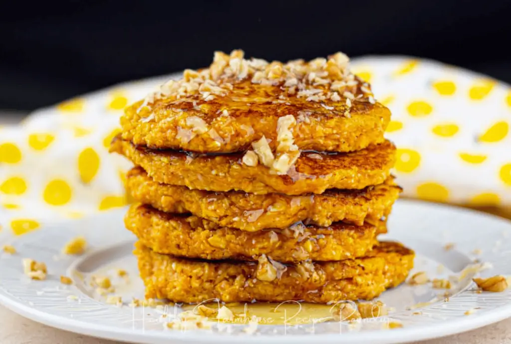 Stack of pumpkin breakfast pancakes toped with nuts