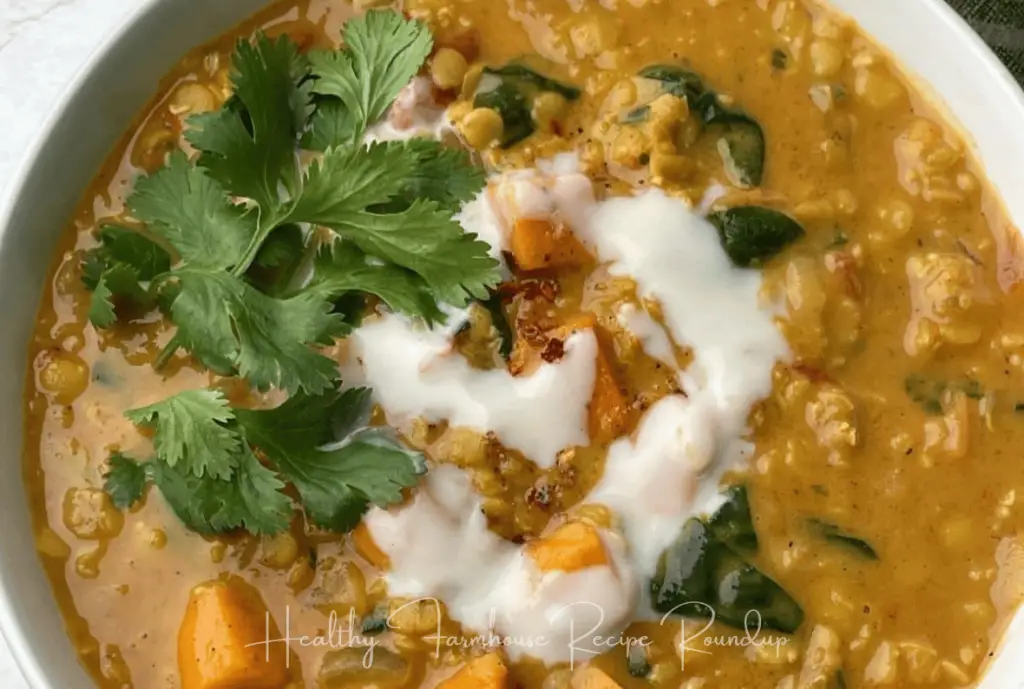 White bowl of brown soup with milk and cilantro for garnish.
