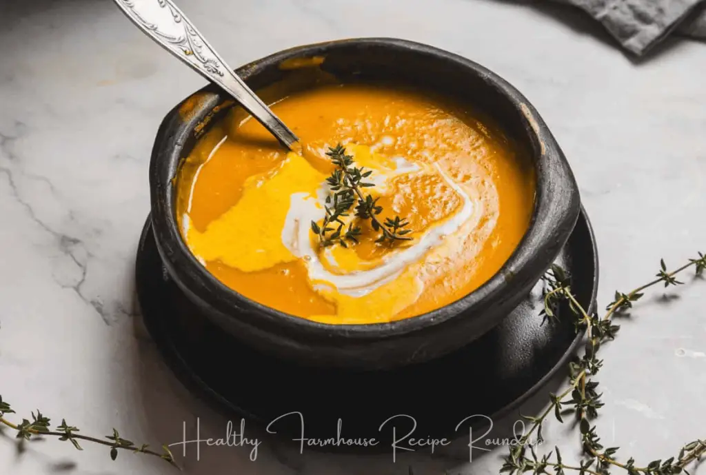 Bright orange fall soup in black cauldron looking bowl