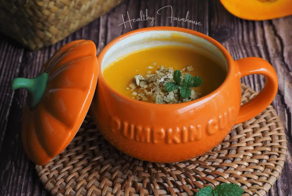 Pumpkin soup in an orange pumpkin shaped mug