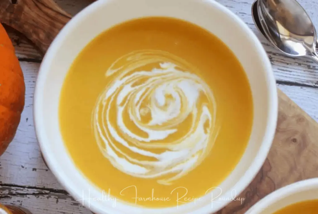 White bowl of pumpkin soup with cream swirl