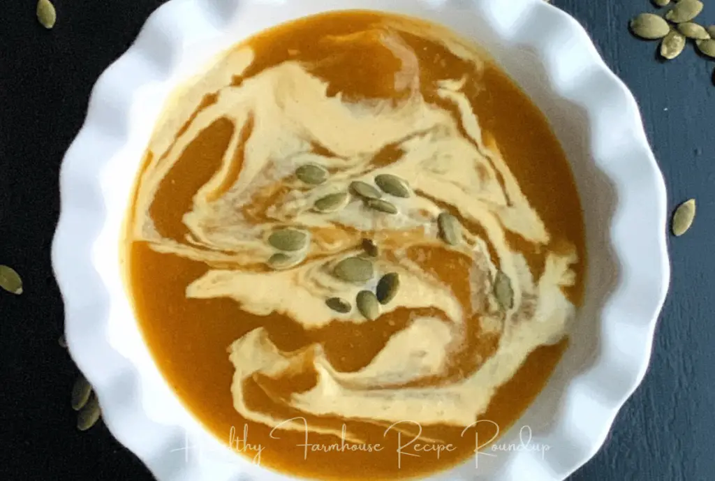 Slow cooker pumpkin soup recipe - Bowl of pumpkin soup with cream and pumpkin seeds