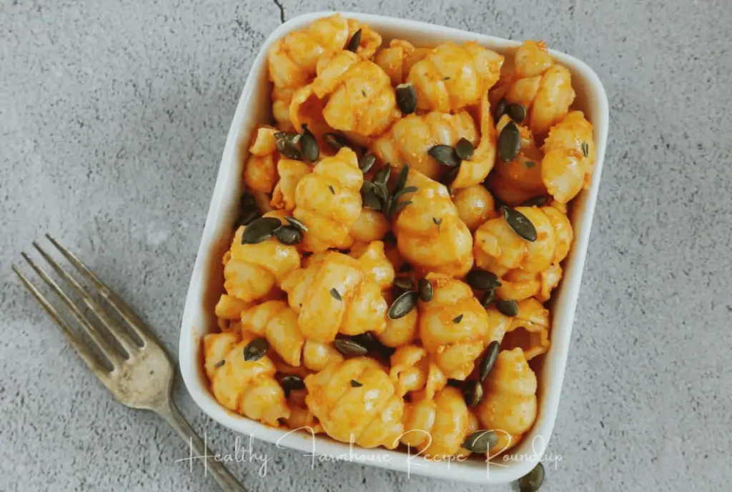Pumpkin pasta in square white dish with pumpkin seeds