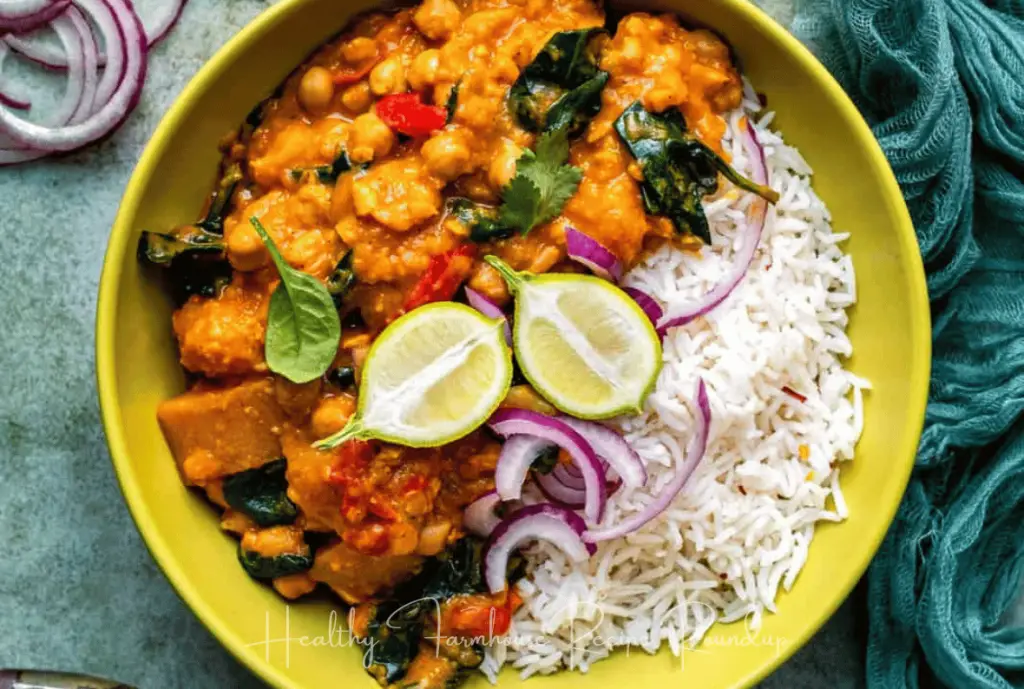 Bright green bowl filled with curry and rice, topped with lime slices.