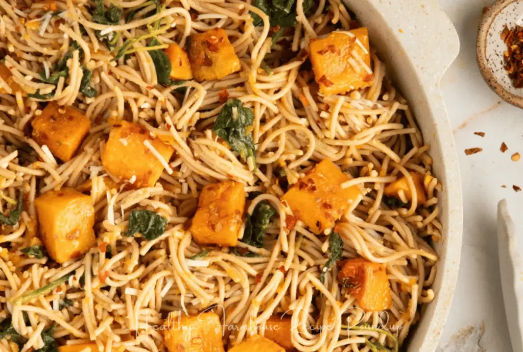 Butternut squash spaghetti pasta bowl: spaghetti noodles with chucks of butternut squash in an off white dish.