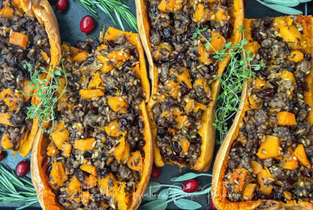 Halved butternut squash filled with sausage mixture and toped with fresh herbs